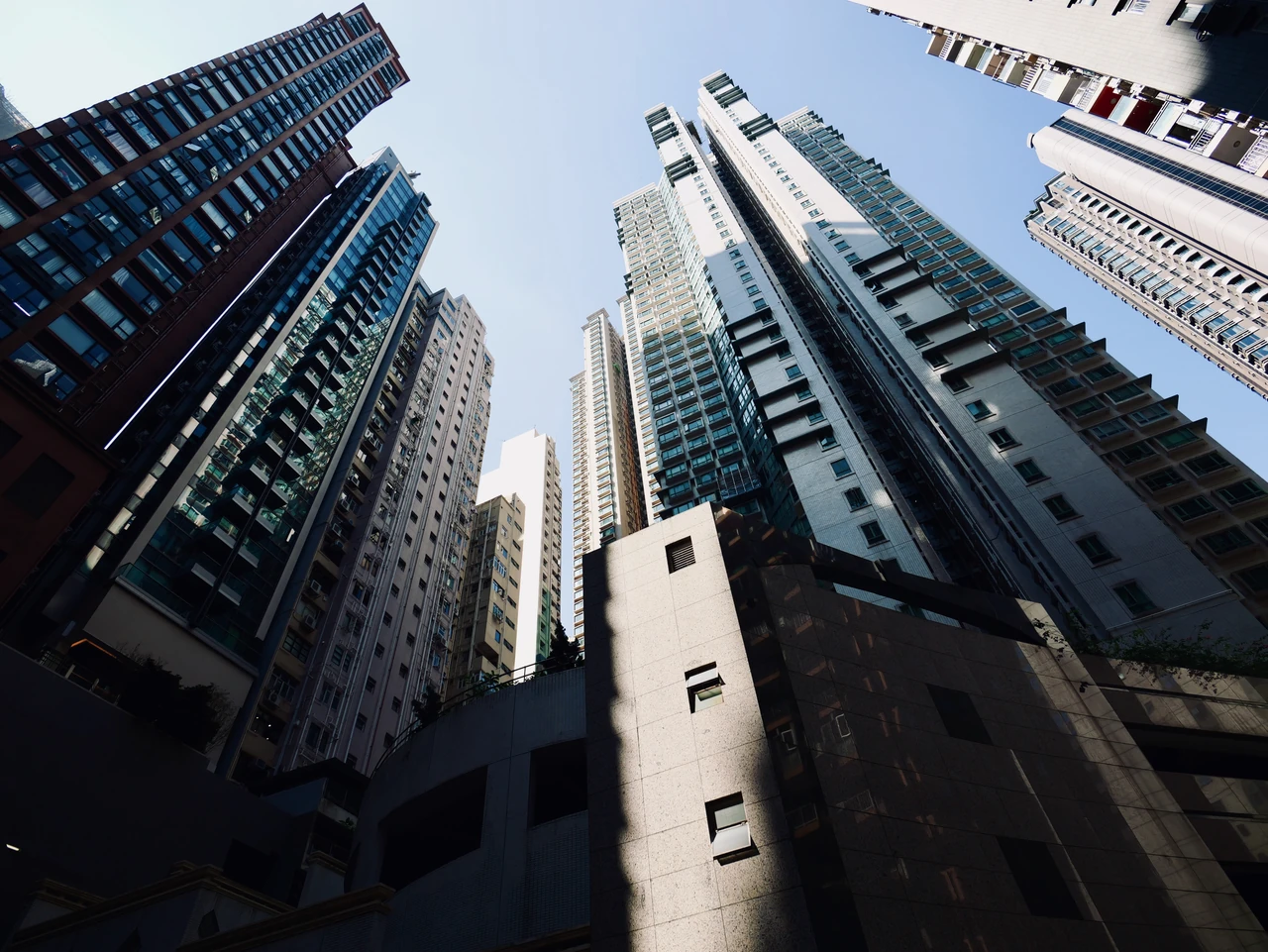 Looking upwards between high-rise buildings towards the sky.