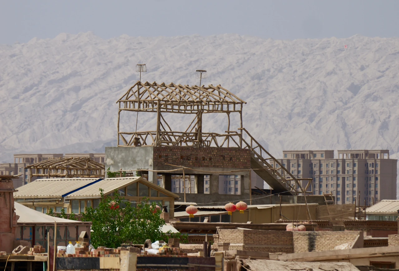 An open structure and stairs beneath barren mountains.